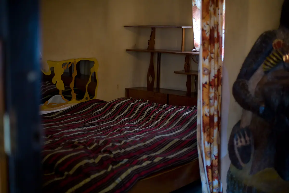 A guest bedroom inside Hang Nga Guesthouse in Da Lat, with curved walls and an animal sculpture by the door