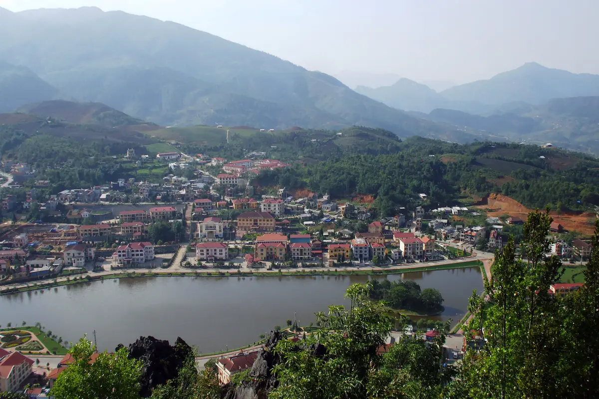 Trung tâm Sa Pa nhìn từ trên cao với hồ nước, dãy nhà mái đỏ và núi phía sau, năm 2010