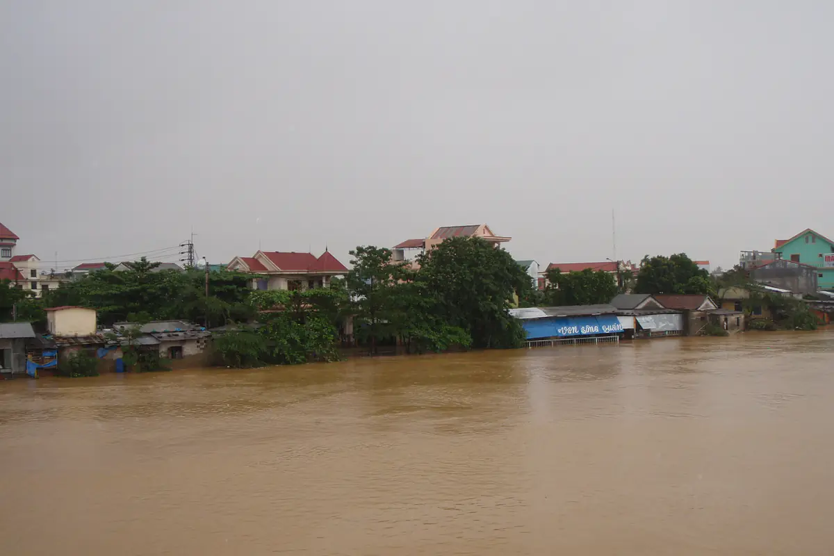 Nước lũ màu nâu đục dâng cao sát mép một khu nhà ven sông ở Huế dưới trời mưa xám, ngày 30/9/2009 khi bão Ketsana gây mưa lớn