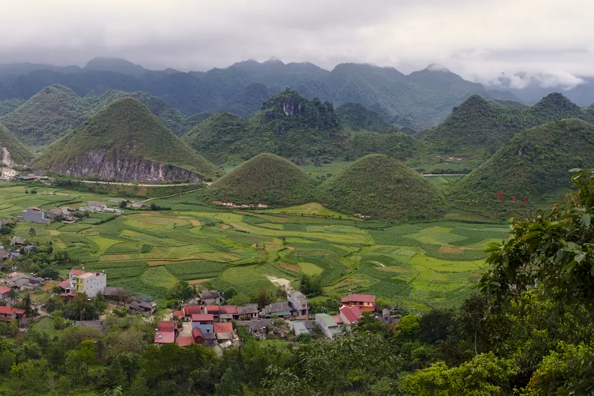 Núi Đôi Quản Bạ hai ngọn tròn giữa ruộng ngô và lúa xanh, nhà dân mái đỏ ở thị trấn Tam Sơn dưới chân Cổng Trời, Hà Giang