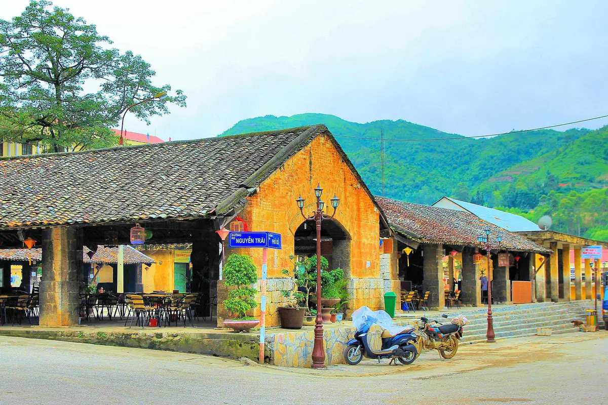 Dãy nhà chợ cổ mái ngói âm dương, tường đá vàng, cột đá ở góc phố Nguyễn Trãi, phố cổ Đồng Văn, tháng 9/2013