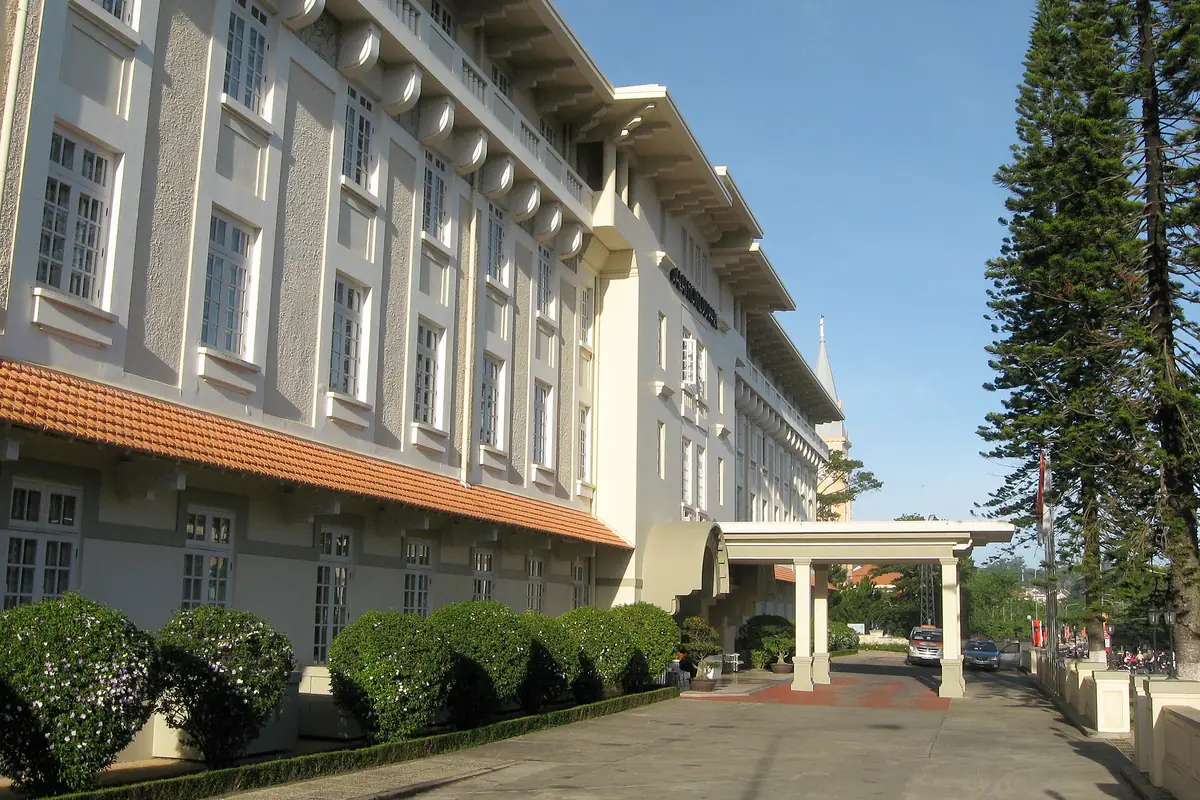 Dãy nhà nhiều tầng tường xám kem của khách sạn Du Parc trên đường Trần Phú, Đà Lạt, xa xa là tháp nhà thờ Con Gà, năm 2011