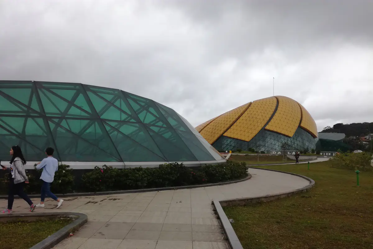 The green and golden glass domes shaped like flower buds at Lam Vien Square, with a curving footpath across the lawn
