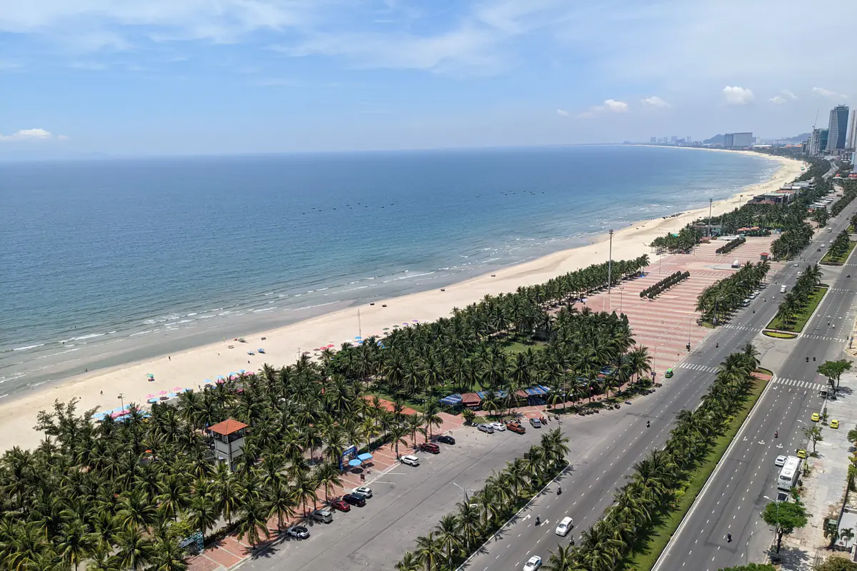 Bãi biển Mỹ Khê, Đà Nẵng nhìn từ trên cao vào một ngày nắng tháng 6/2022, nước biển xanh trong, bãi cát dài và hàng dừa chạy dọc con đường ven biển