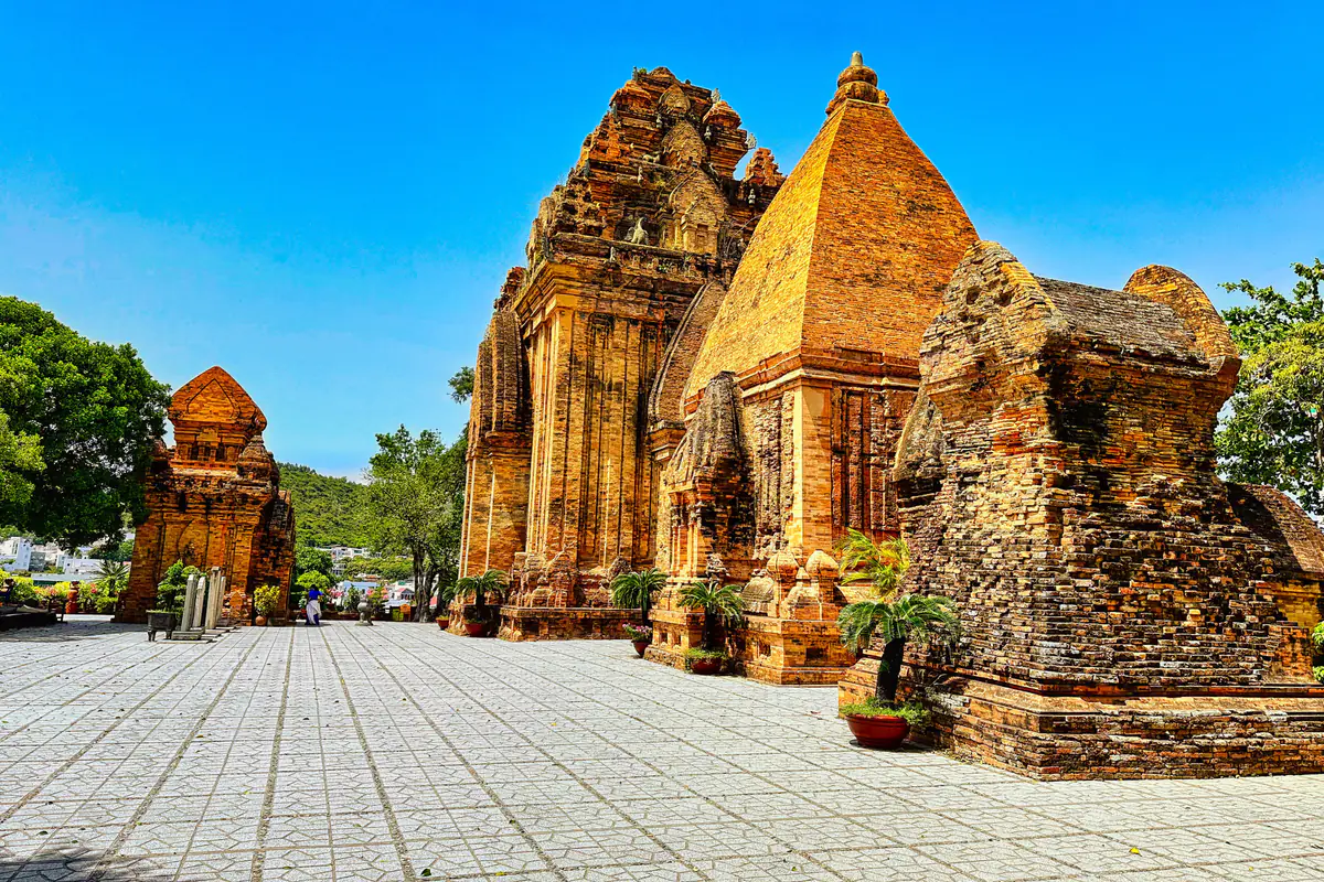 Các tháp Chăm bằng gạch đỏ của khu Tháp Bà Ponagar trên đồi ở Nha Trang, sân lát gạch phía trước, trời xanh tháng 4/2023